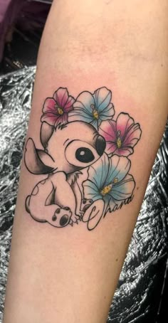 a small tattoo on the arm of a girl with flowers in her hair and an elephant's head