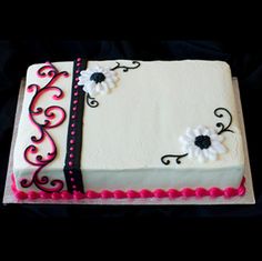 a white cake with pink and black decorations