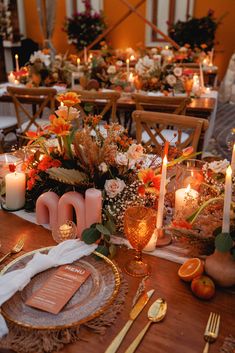 the table is set with candles, plates and napkins for dinner guests to eat