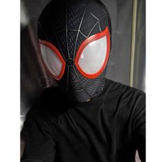 a man wearing a spider - man mask with red eyes