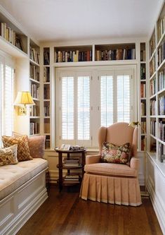 a living room filled with lots of furniture and bookshelves next to a window