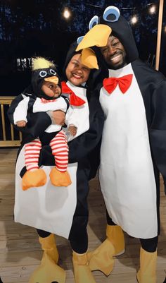 two adults and a child dressed in penguin costumes