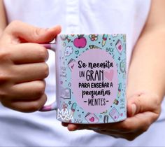 a person holding a coffee mug with writing on the front and bottom, in their hands