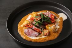 a black plate topped with food on top of a table