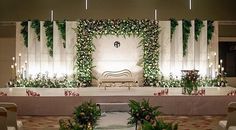 an indoor wedding setup with flowers and greenery