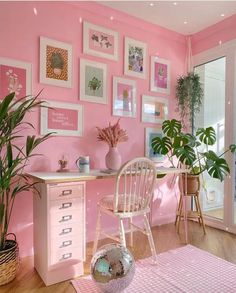 a pink room with lots of pictures on the wall and a chair in front of it