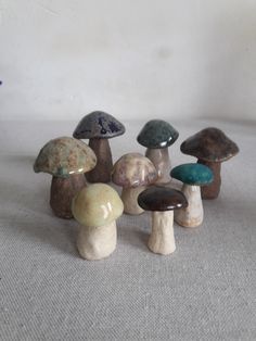 several different colored mushrooms sitting on top of a white cloth covered floor next to each other