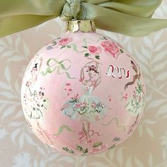 a pink ball ornament with a green bow hanging from it's side