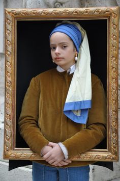 a girl with a pearl earring holding a painting