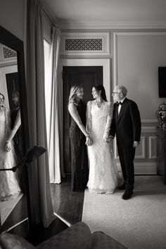 a bride and groom standing in front of a mirror