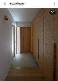 an empty hallway with wooden doors and white walls