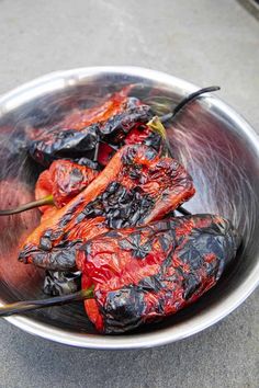 some red peppers are in a silver bowl