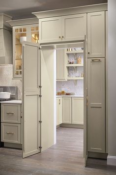 an open door in a kitchen next to a counter top oven and cabinets with drawers