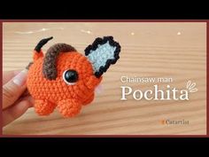 a small orange crocheted animal with black eyes and horns on it's head