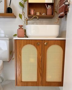 a bathroom with a sink, toilet and cabinet in it's own area is shown