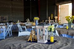 a table topped with a white lantern and yellow flowers