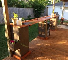 an outdoor bar made out of cinder blocks and some plants on the back porch area