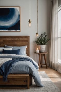 a bed with blue and white linens in a bedroom next to a painting on the wall