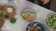 a table topped with bowls filled with different types of food and vegetables on top of it