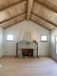 an empty living room with wood floors and exposed beams on the ceiling is seen in this image