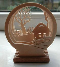 a paperweight with a house and tree in the center on a window sill