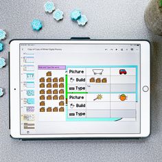 a tablet with pictures on the screen next to some blue candies and a potted plant