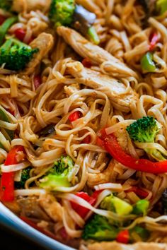 noodles with chicken, broccoli and peppers in a bowl