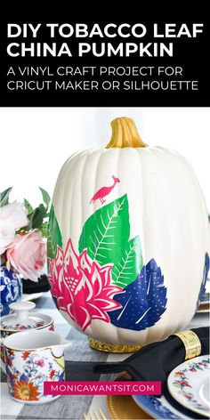 a white pumpkin painted with colorful flowers and leaves on it, sitting on a table