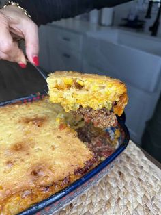 a person cutting into a casserole with a knife