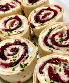 several rolls with cream cheese and cranberry sauce on them sitting on a white plate