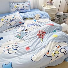 a bed with blue sheets and cartoon characters on it