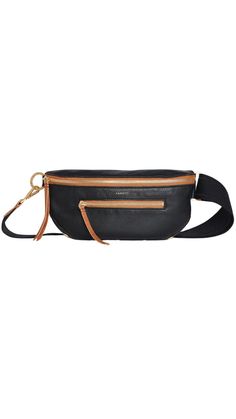 This updated take on our internet famous belt bag embraces the crossbody styling our fans have come to love. It has been updated with a long strap, which allows you to truly wear this style as a low slung crossbody, in addition to over your chest. Crafted with soft black leather featuring a saddle brown trim Red cotton twill lining Brushed Gold Hardware Piping Details Front zippered pocket and back zippered cell phone pocket Zipper closure; interior credit card slot Molds easily to body Wear as Black Leather Belt Bag With Zipper Closure, Black Leather Belt Bag With Zipper, Luxury Black Belt Bag With Zipper Closure, Versatile Black Leather Belt Bag, Trendy Leather Belt Bag With Zipper Closure, Versatile Black Soft Leather Belt Bag, Trendy Leather Belt Bag With Removable Belt, Versatile Black Bag With Removable Belt, Trendy Leather Belt Bag With Detachable Strap