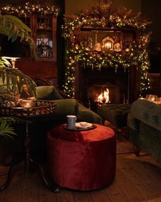 a living room filled with furniture and a fire place covered in christmas lights, surrounded by greenery