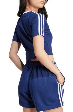 A center Trefoil logo and 3-Stripes at the sleeves root this sporty, cropped T-shirt in heritage adidas style. Crewneck Short sleeves 94% cotton, 6% elastane Machine wash, dry flat Imported Summer Athleisure T-shirt With Three Stripes, Blue Athleisure T-shirt With Three Stripes Branding, Blue Sporty T-shirt With Contrast Stripes, Cropped Cotton Sports T-shirt, Cropped Cotton T-shirt For Sports, Casual Three Stripes T-shirt For Sports Events, Sporty Blue Cropped T-shirt For Spring, Sporty Short Sleeve T-shirt With Side Stripes, Sporty Moisture-wicking Cropped T-shirt