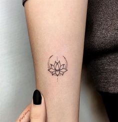 a woman's arm with a lotus tattoo on the left side of her arm