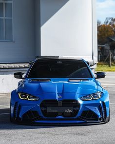 a blue sports car parked in front of a building