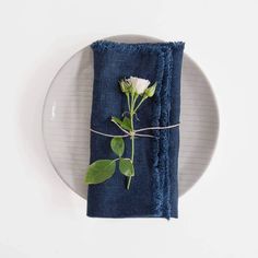 a plate with a napkin and flower on it