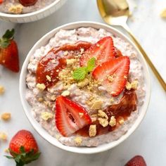 a bowl filled with oatmeal and strawberries on top of a table