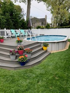 an above ground pool with steps leading up to it and potted plants on the side