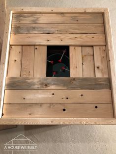 a wooden box with a clock in the center and holes in the bottom that are made to look like wood