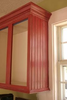 an old red cabinet in the corner of a room