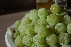 a white bowl filled with green grapes on top of a table