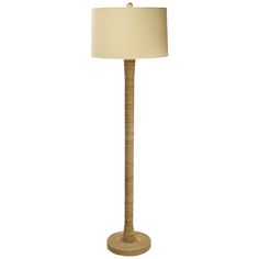 a floor lamp with a beige shade on it's base and a white linen lampshade