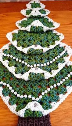 a crocheted christmas tree is sitting on the floor