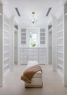 an empty white room with lots of shelves and drawers