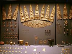 an assortment of gold jewelry on display in a museum