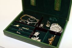 an open green box with jewelry in it