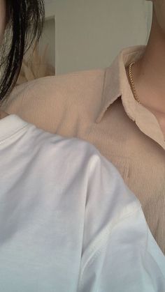 a close up of a person wearing a collared shirt and holding a baby in her arms