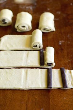 rolled up dough sitting on top of a wooden table