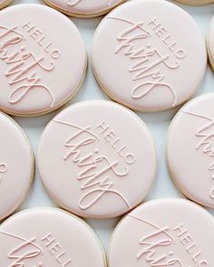 some cookies that are sitting on top of a white tablecloth with words written in cursive writing